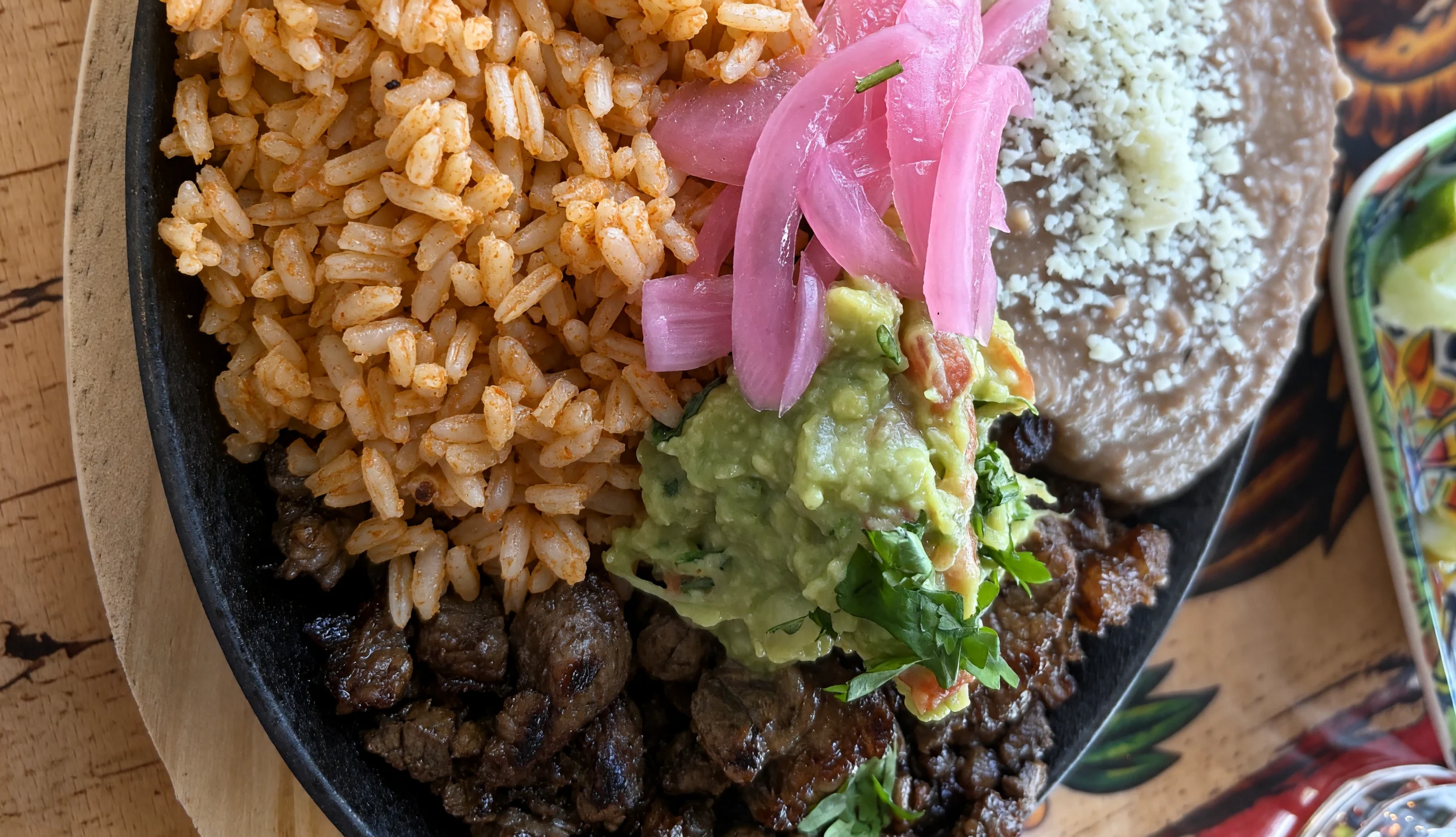 Carne asada platter with Mexican rice, house beans, guacamole and pickled onion at MEXIKAN in Heritage Valley, Edmonton
