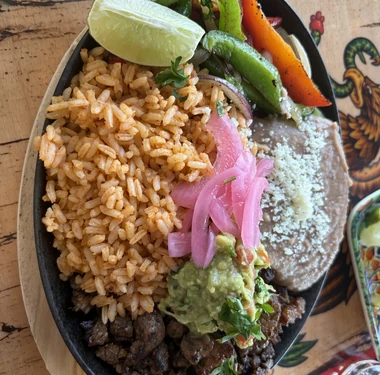 Carne asada platter with Mexican rice, house beans, guacamole and pickled onion at MEXIKAN in Heritage Valley, Edmonton