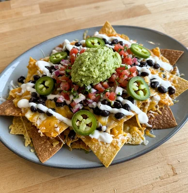 Loaded nachos with black beans, pico de gallo, jalapeños, crema and guacamole