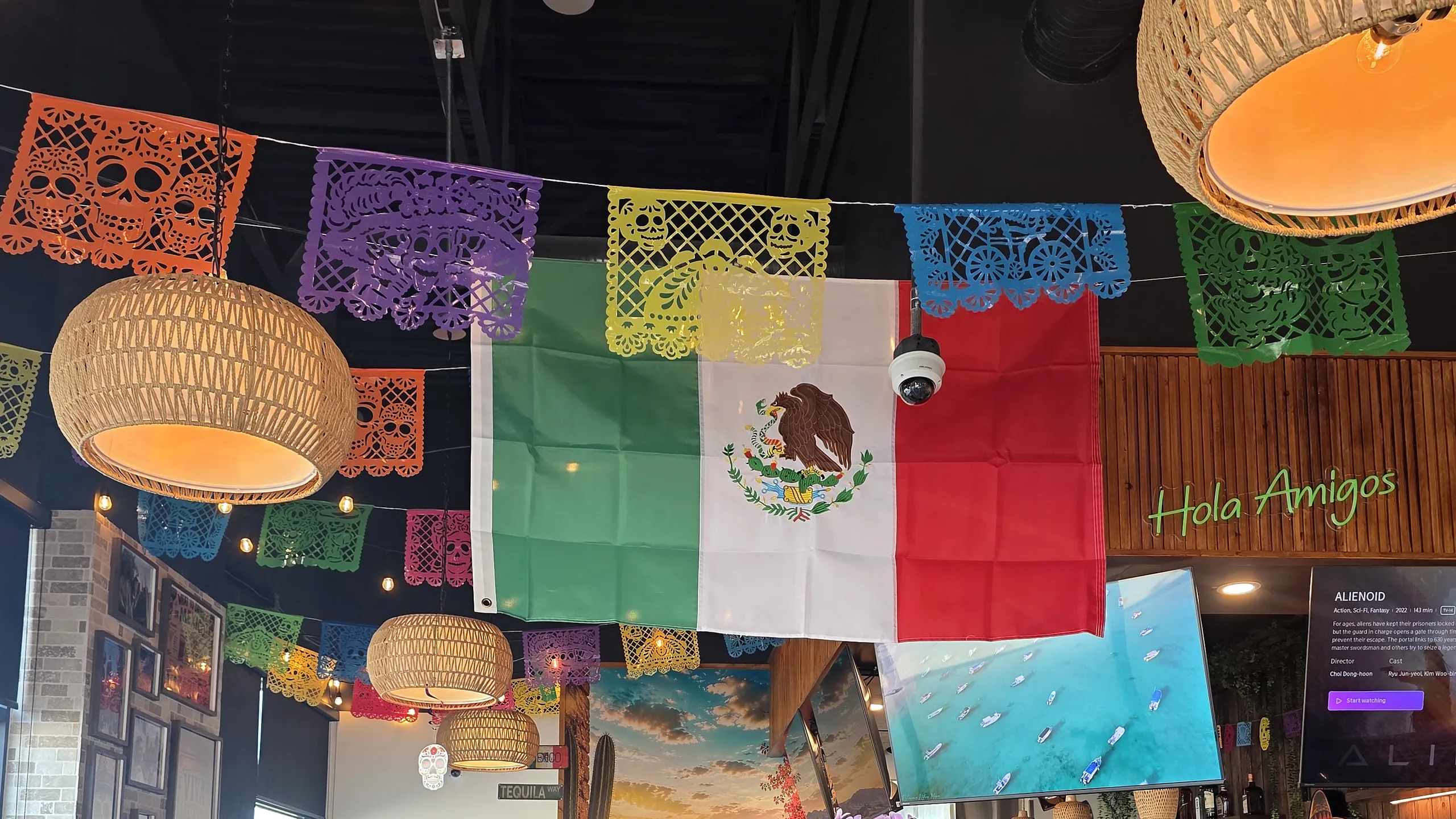 Dining room at MEXIKAN in Heritage Valley, Edmonton, with papel picado and a Mexican flag