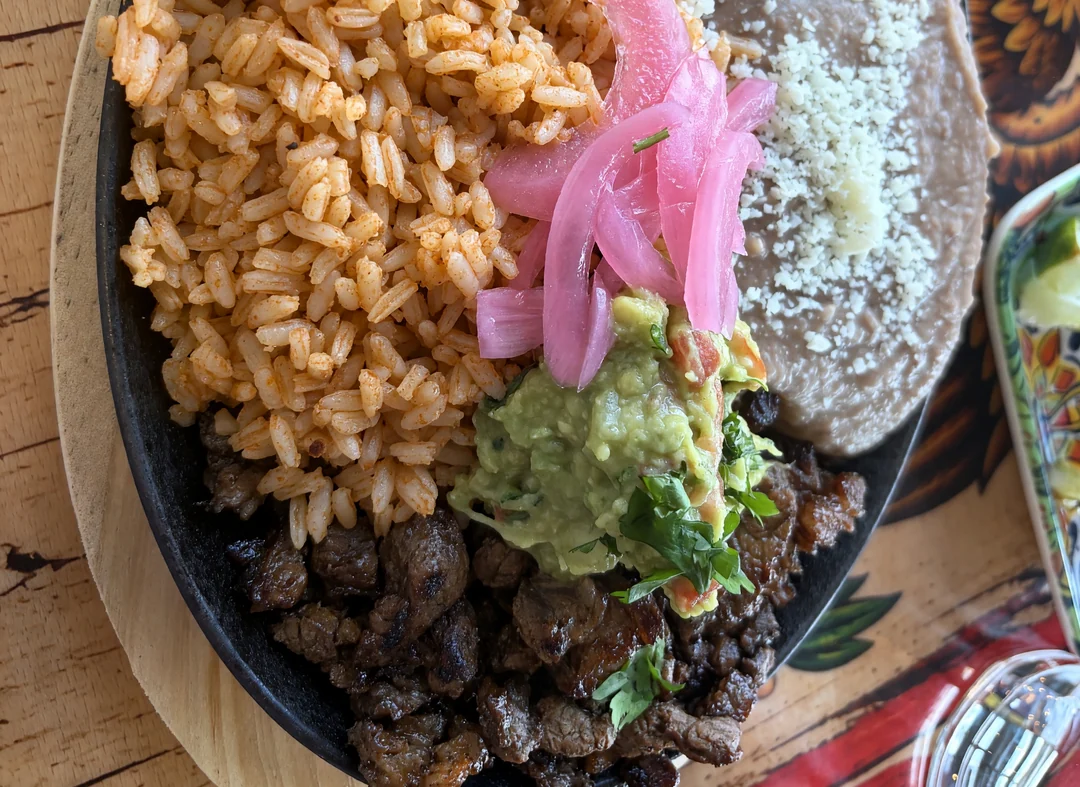 Carne asada platter with Mexican rice, house beans, guacamole and pickled onion at MEXIKAN in Heritage Valley, Edmonton