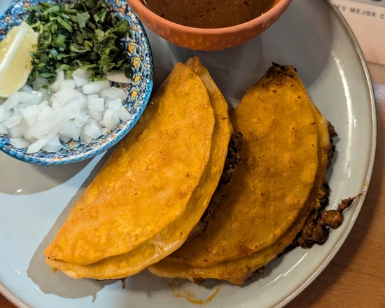 Quesabirria tacos with consommé, onion, cilantro and lime at MEXIKAN in Heritage Valley, Edmonton